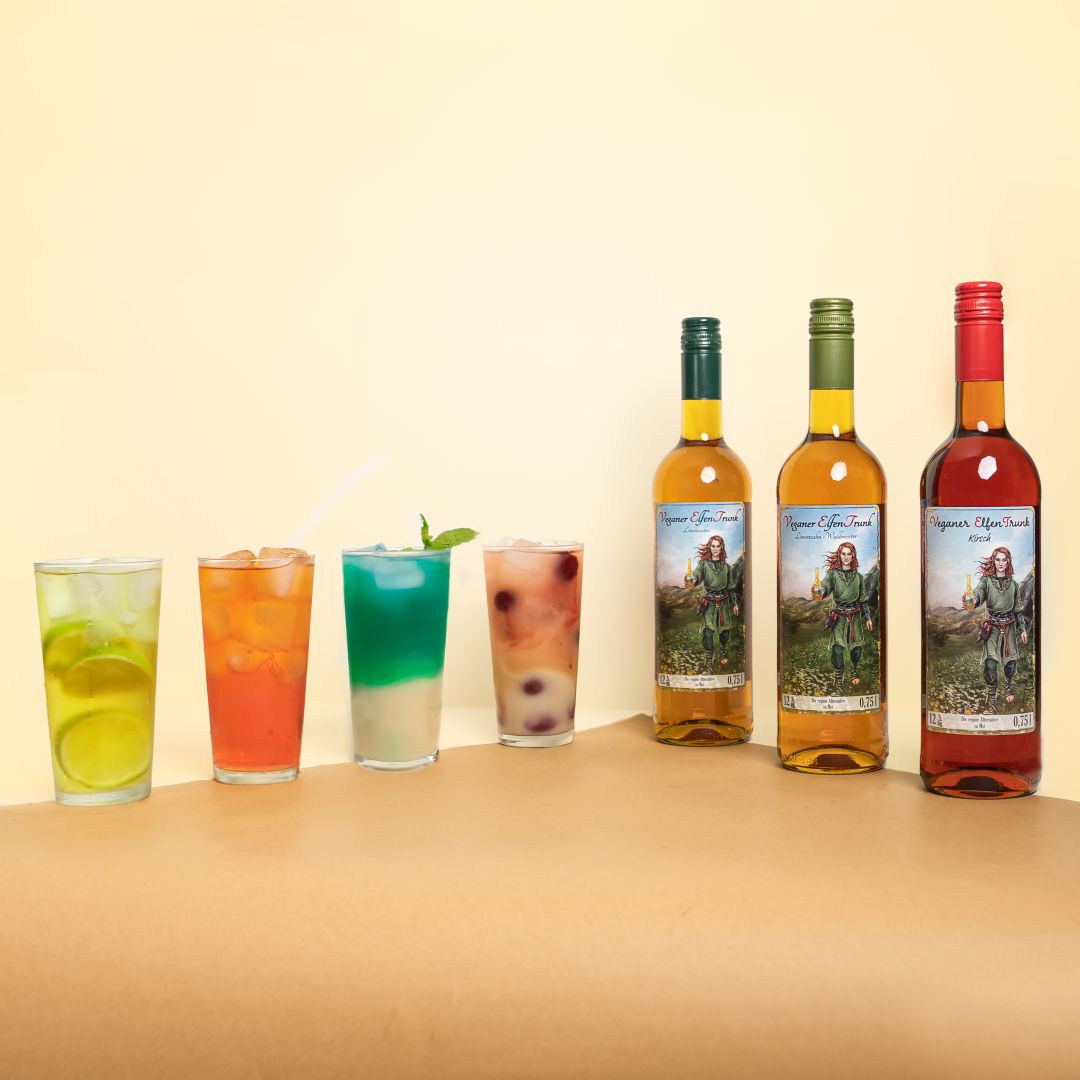 Eine Auswahl köstlicher Cocktails, darunter der vegane ElfenTrunk, der vegane Met, serviert in stilvollen Gläsern. Die perfekte Kombination aus erfrischenden Aromen und veganem Genuss