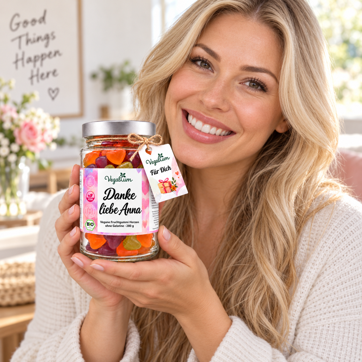 Blonde Frau präsentiert personalisierte Vegablum Fruchtgummi Herzen 280 g mit dem Wunschtext Danke liebe Anna und Für Dich Anhänger.